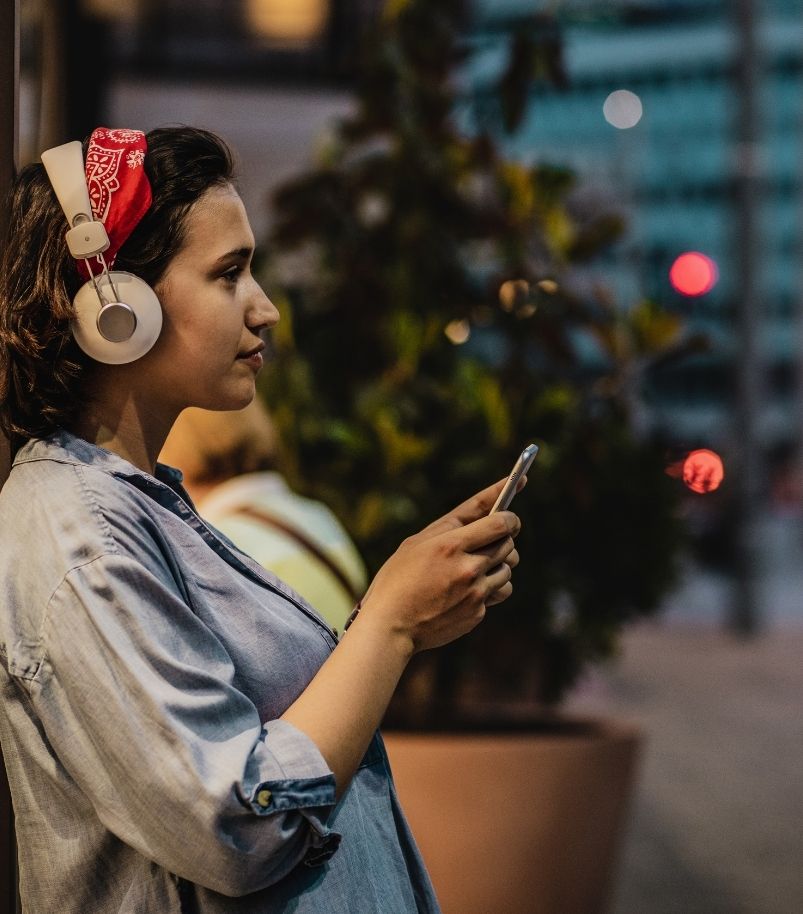 latina woman listening to the healthy project podcast while waiting for uber